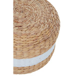 Round pouffe made from natural water hyacinth, featuring a textured woven design with a prominent white stripe around its circumference. The pouffe is shown from a top-down angle, highlighting its circular shape and the contrast between the natural fibers and the white stripe