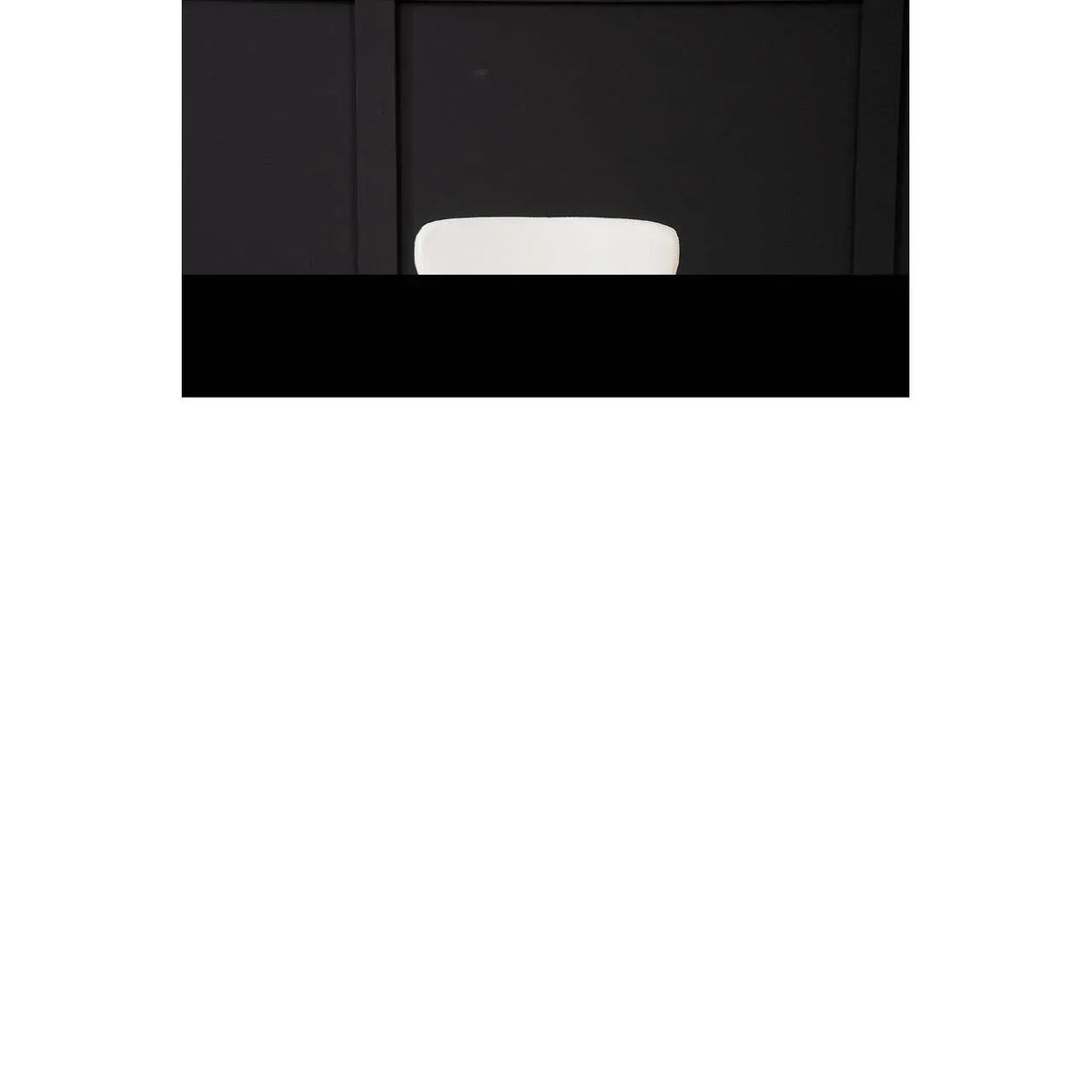 White dining chair with curved backrest against black paneled wall