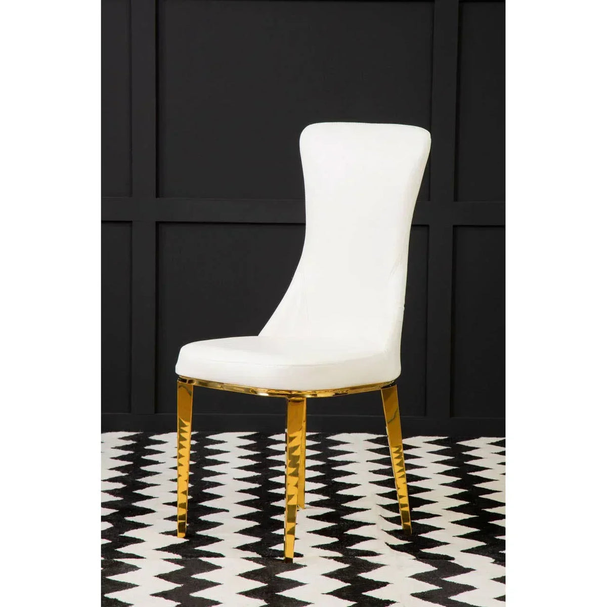 White dining chair with gold metal legs on black and white patterned floor