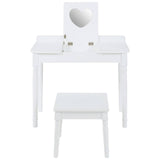 White children's dressing table with a heart-shaped mirror and two small drawers, accompanied by a matching white stool. The furniture features clean lines and a simple design, suitable for a child's room