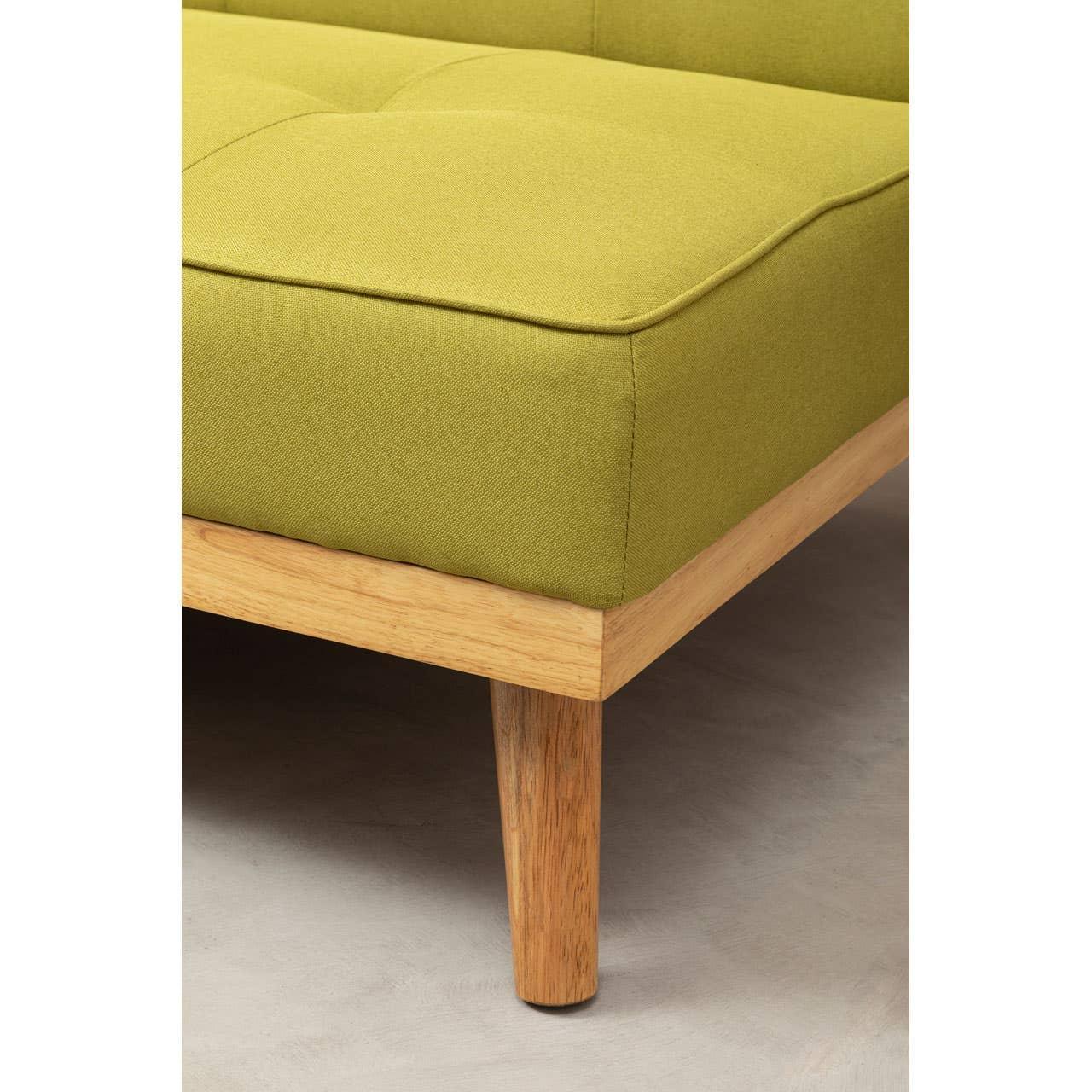 Closeup of green fabric sofa with wooden leg and tufted seat detail
