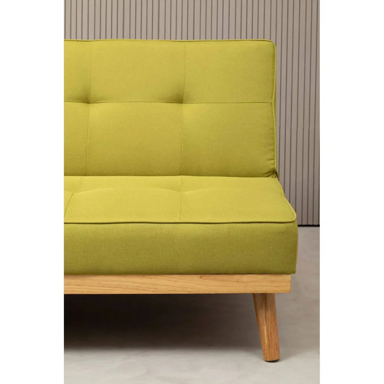 Green upholstered sofa with wooden legs, close view of corner and seat detail