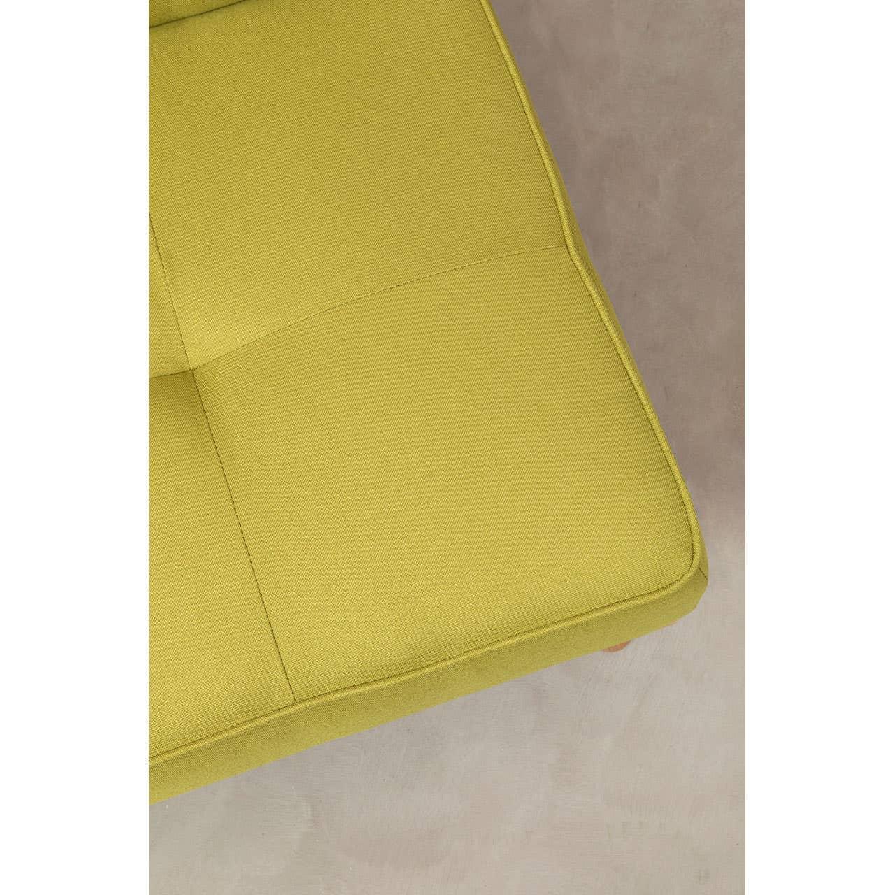 Close-up of green fabric sofa seat with button detail on neutral floor