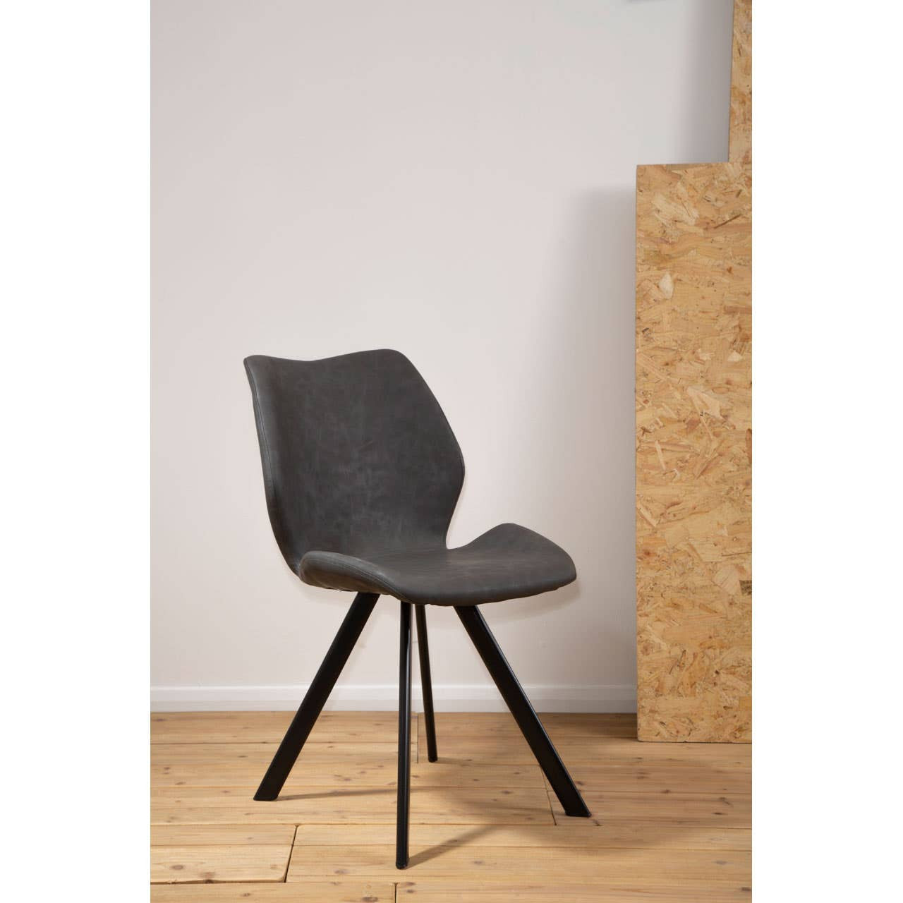Round dining table with a marble effect surface, surrounded by six stylish chairs featuring a modern design and black legs. The setting includes a light wooden floor and a neutral wall backdrop, creating a contemporary dining atmosphere