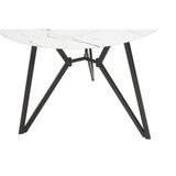 Round dining table with a white marble effect top and a modern black metal base featuring angular legs, accompanied by six matching chairs with a sleek design