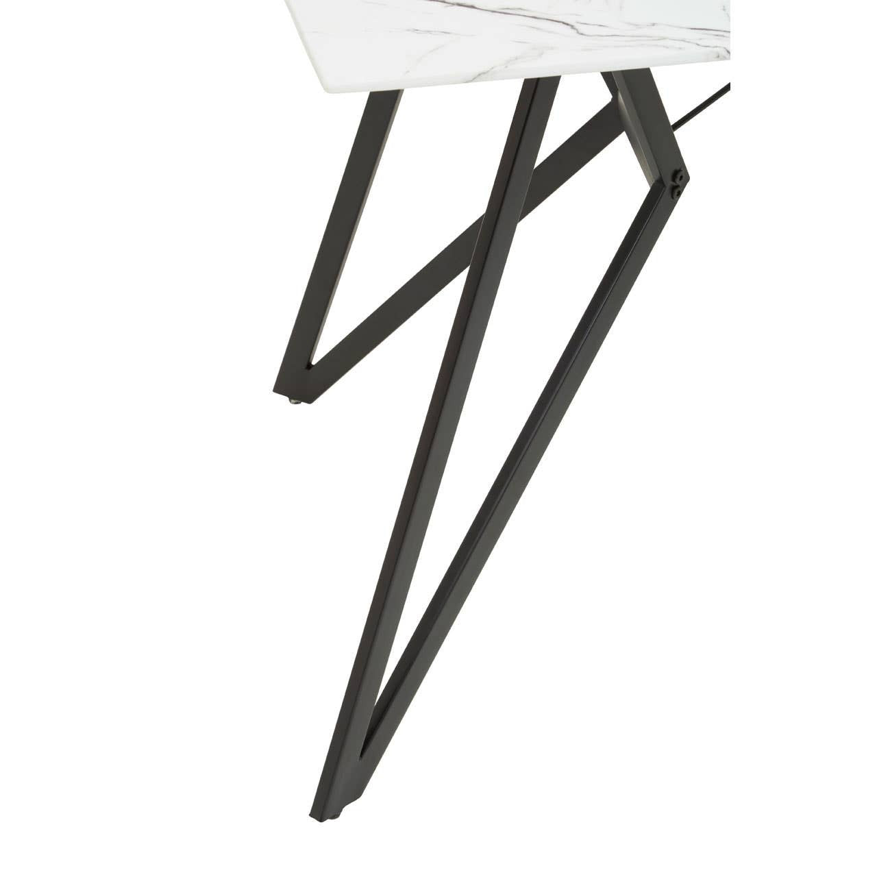 Marble effect dining table with a sleek white surface and modern black metal legs featuring a geometric design. The image focuses on the unique angular leg structure, highlighting the contemporary style of the furniture