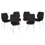 A sleek black tempered glass dining table accompanied by six modern black chairs with a minimalist design and slender metal legs, arranged around the table. The overall aesthetic is contemporary and elegant, suitable for a dining area