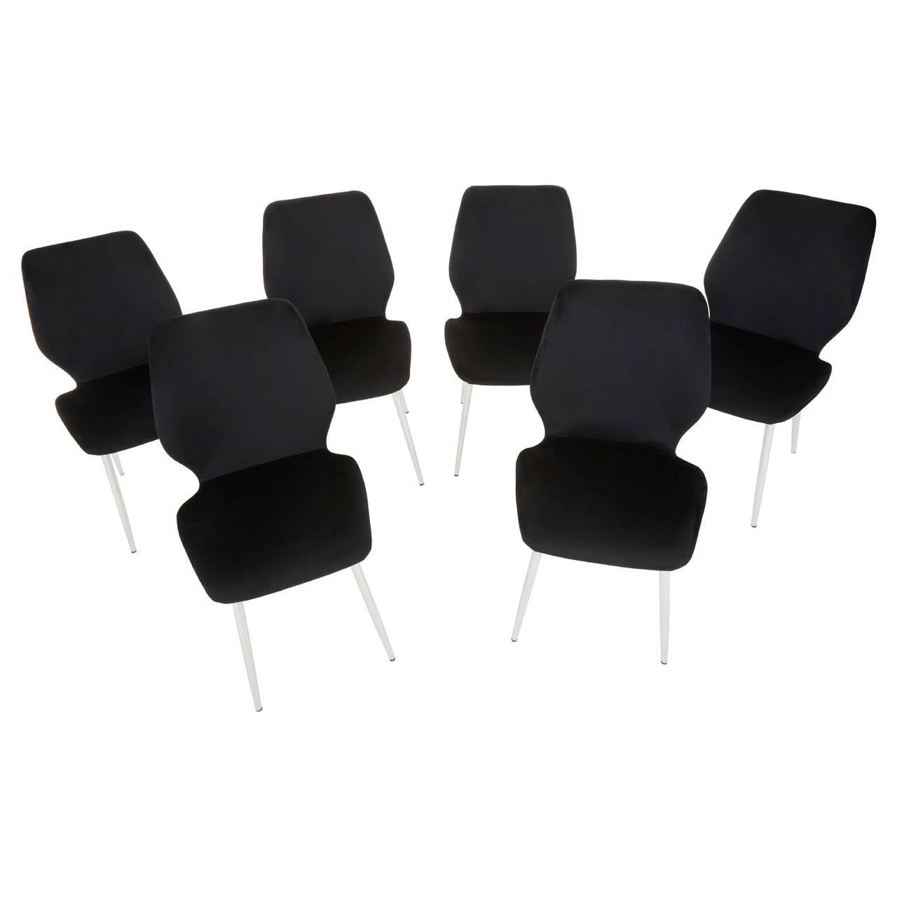 Wimslow black tempered glass dining table accompanied by six sleek black chairs with modern design and metal legs, arranged around the table. The table features a smooth glass surface, reflecting light, while the chairs have a minimalist aesthetic with curved backs
