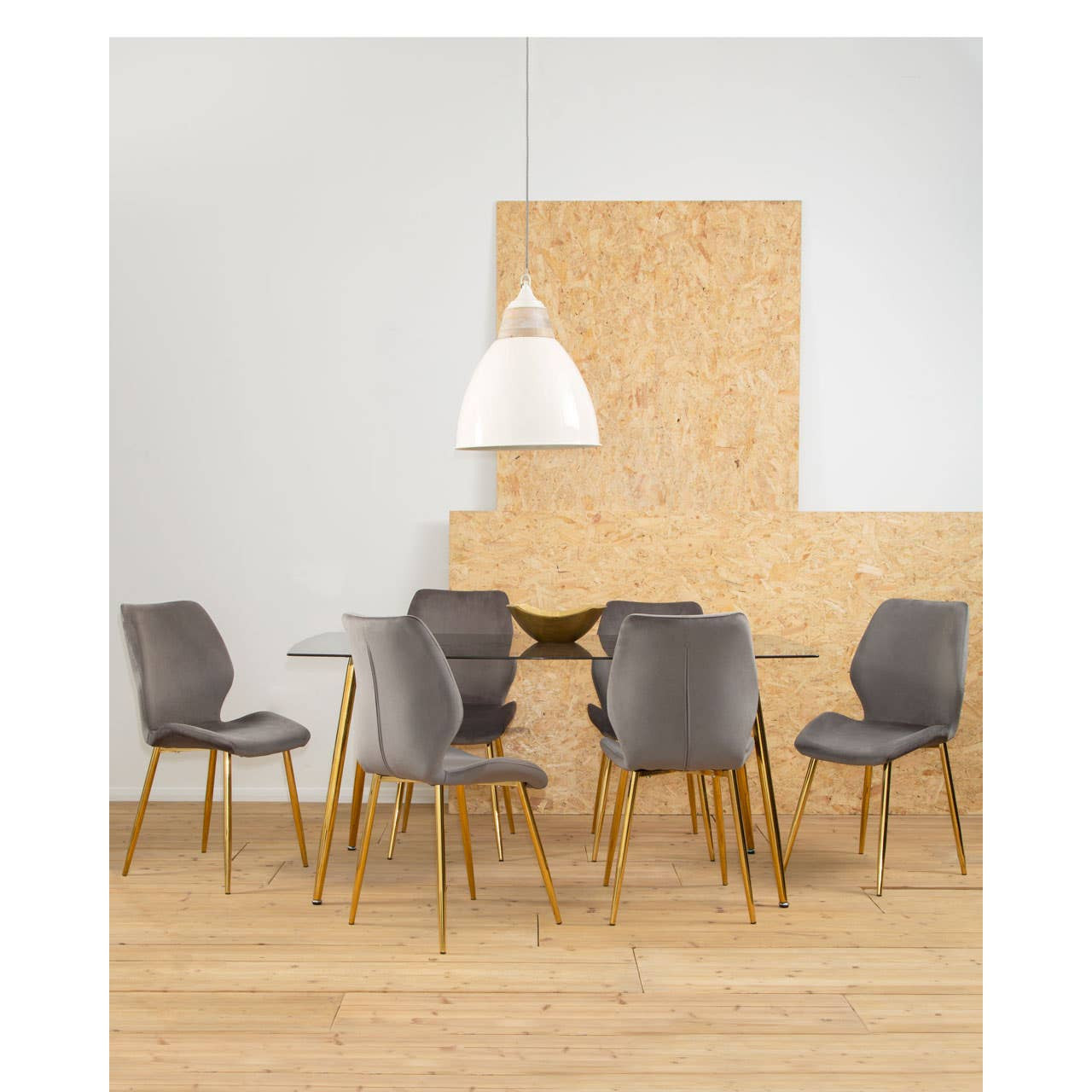 Smoked glass dining table surrounded by six upholstered chairs with wooden legs, set against a light-colored wall and a textured wooden feature wall. A pendant light hangs above the table, illuminating the space. The floor is made of light wood, creating a warm and inviting atmosphere