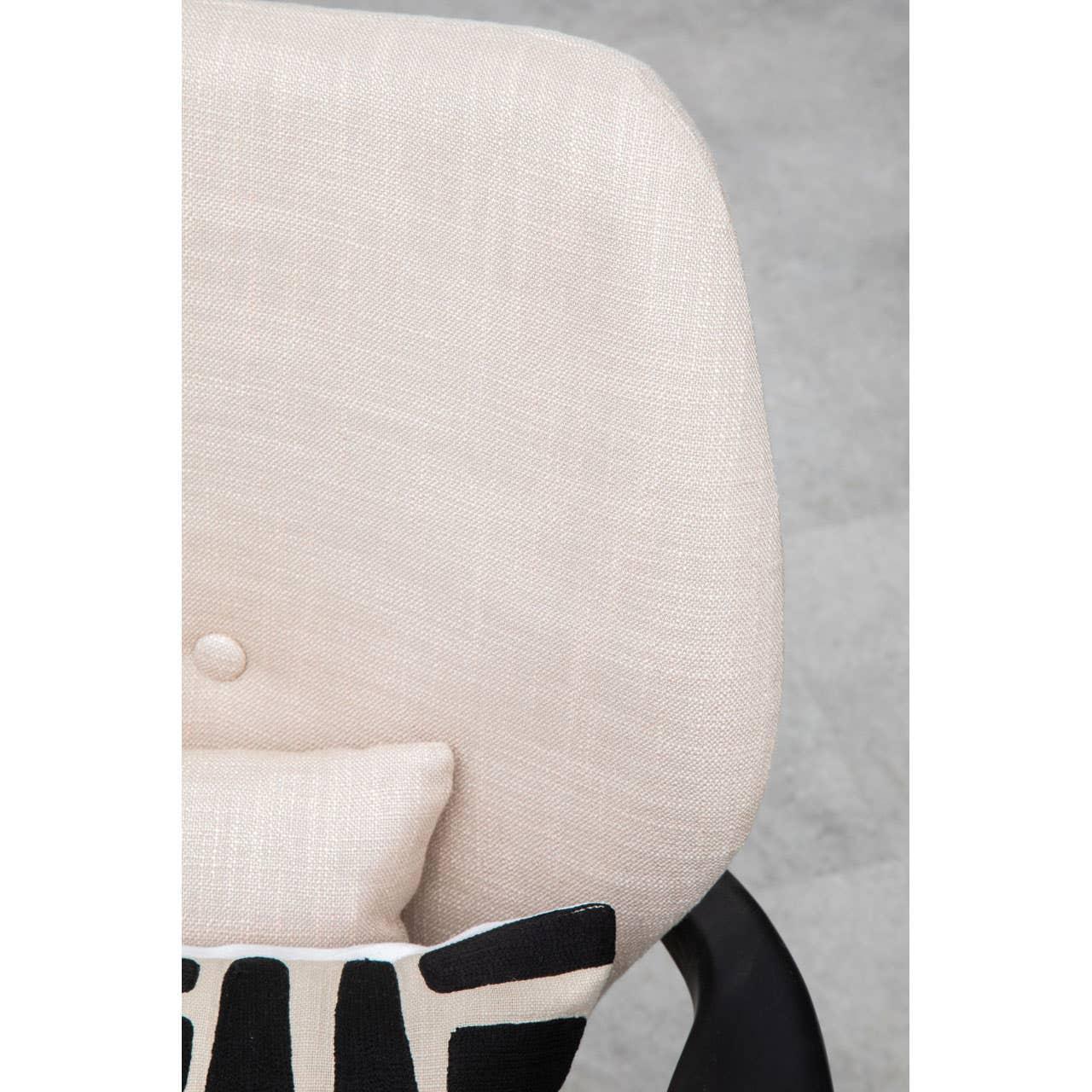 Beige fabric accent chair backrest with patterned cushion and button detail