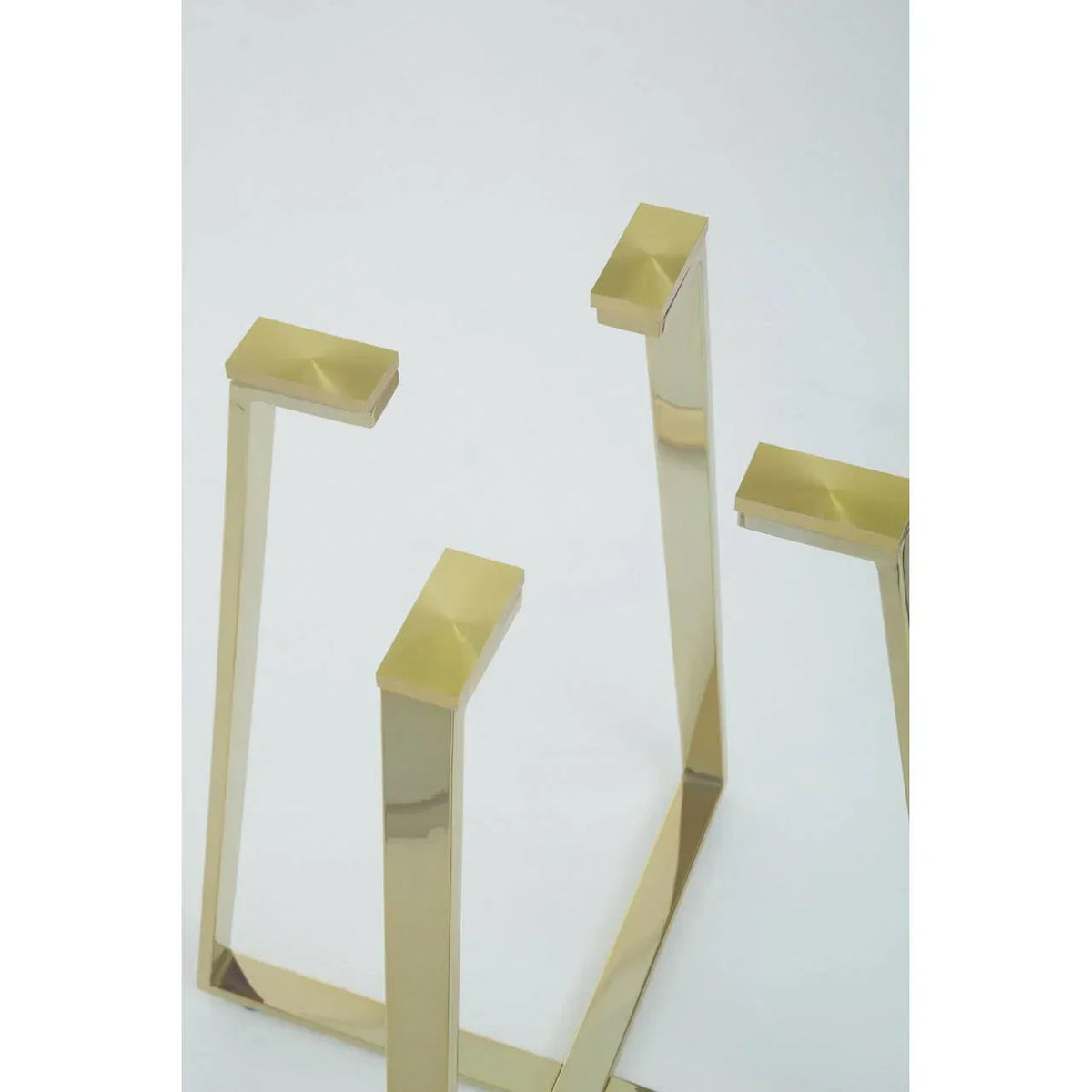 gold metal table legs with modern geometric design on white background