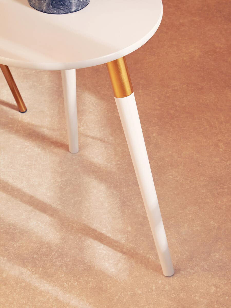 Light grey side table with a round top and tapered white legs featuring gold accents, set against a soft beige background with subtle shadows