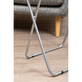 Folding table with a sand black top and a silver metal frame, positioned on a wooden floor, with part of a couch visible in the background