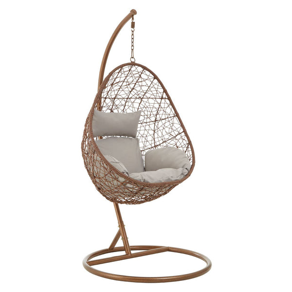 A brown rattan hanging chair with a unique teardrop shape, featuring a cushioned seat in a light gray fabric. The chair is suspended from a curved metal stand, which has a circular base for stability. The woven rattan design showcases an intricate pattern, adding a stylish touch to the overall look