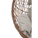 A close-up view of the Goa Brown Rattan Hanging Chair, showcasing its woven rattan structure and soft, light gray cushions nestled inside the chair's curved design. The natural brown tones of the rattan contrast with the neutral fabric, creating a cozy and inviting appearance