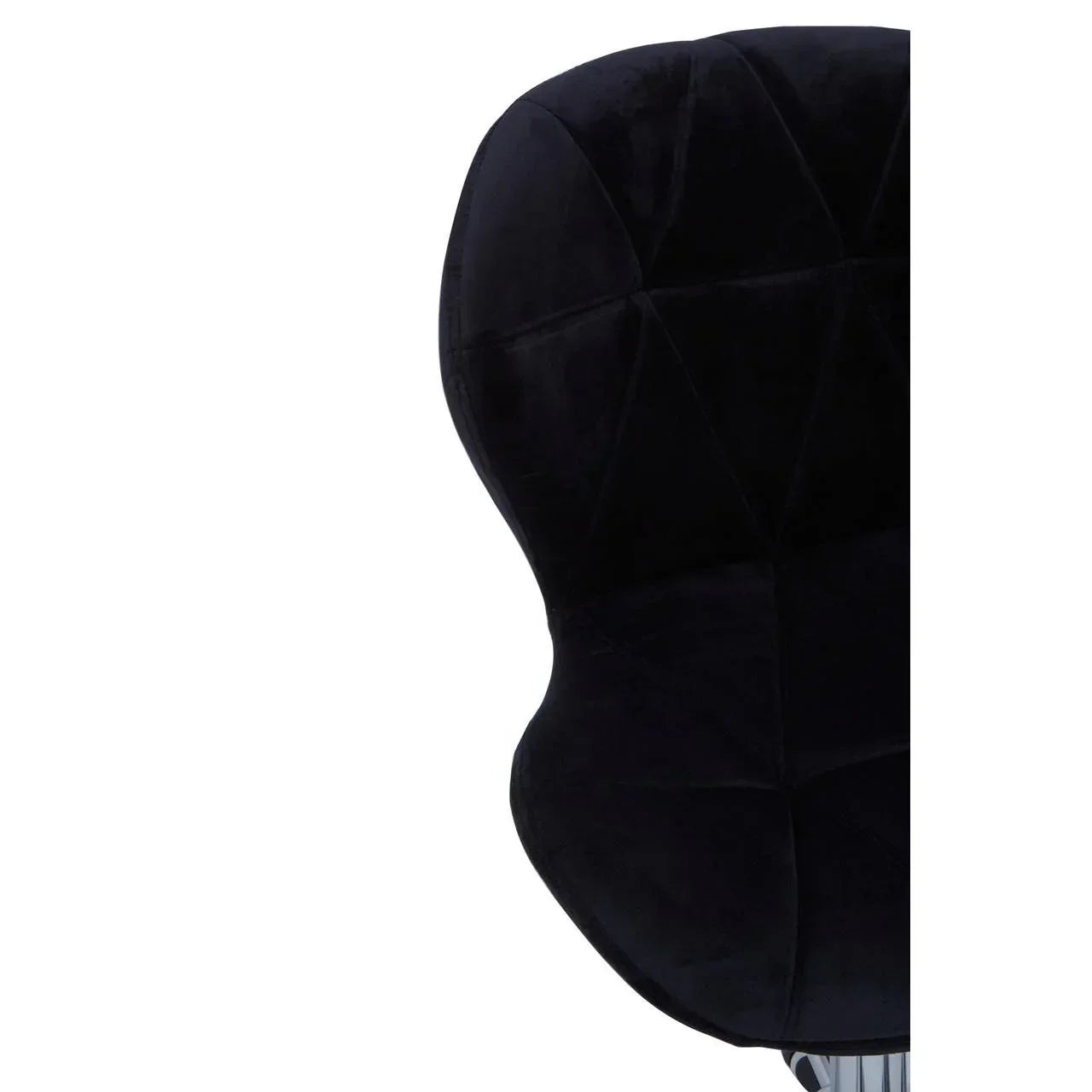 Closeup of black velvet dining chair with curved stitched backrest
