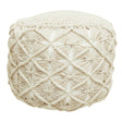 A round, knitted pouffe in a soft cream color featuring a textured, crisscross pattern on the exterior, designed for use as a footrest or additional seating in a home setting