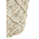 A close-up view of a West Village knitted pouffe featuring a textured, cream-colored design with intricate patterns created by interwoven yarn. The pouffe has a rounded shape and a soft, cozy appearance, ideal for home decor