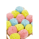 A colorful stool featuring a playful arrangement of pink, blue, and yellow pom poms on a neutral base, adding a whimsical touch to home decor