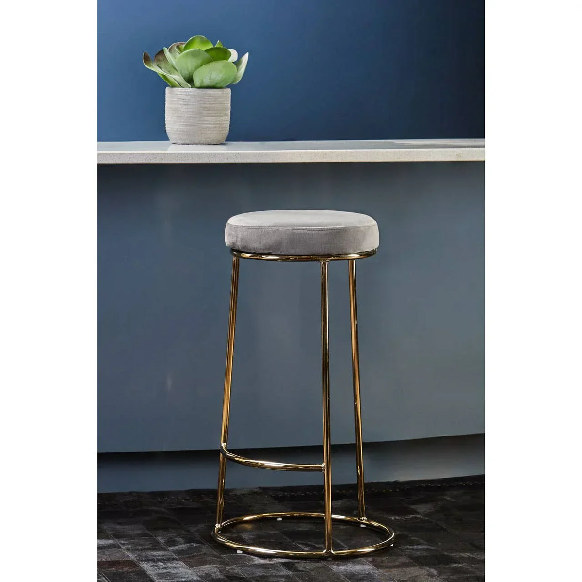 Grey velvet bar stool with gold metal legs at blue kitchen breakfast bar