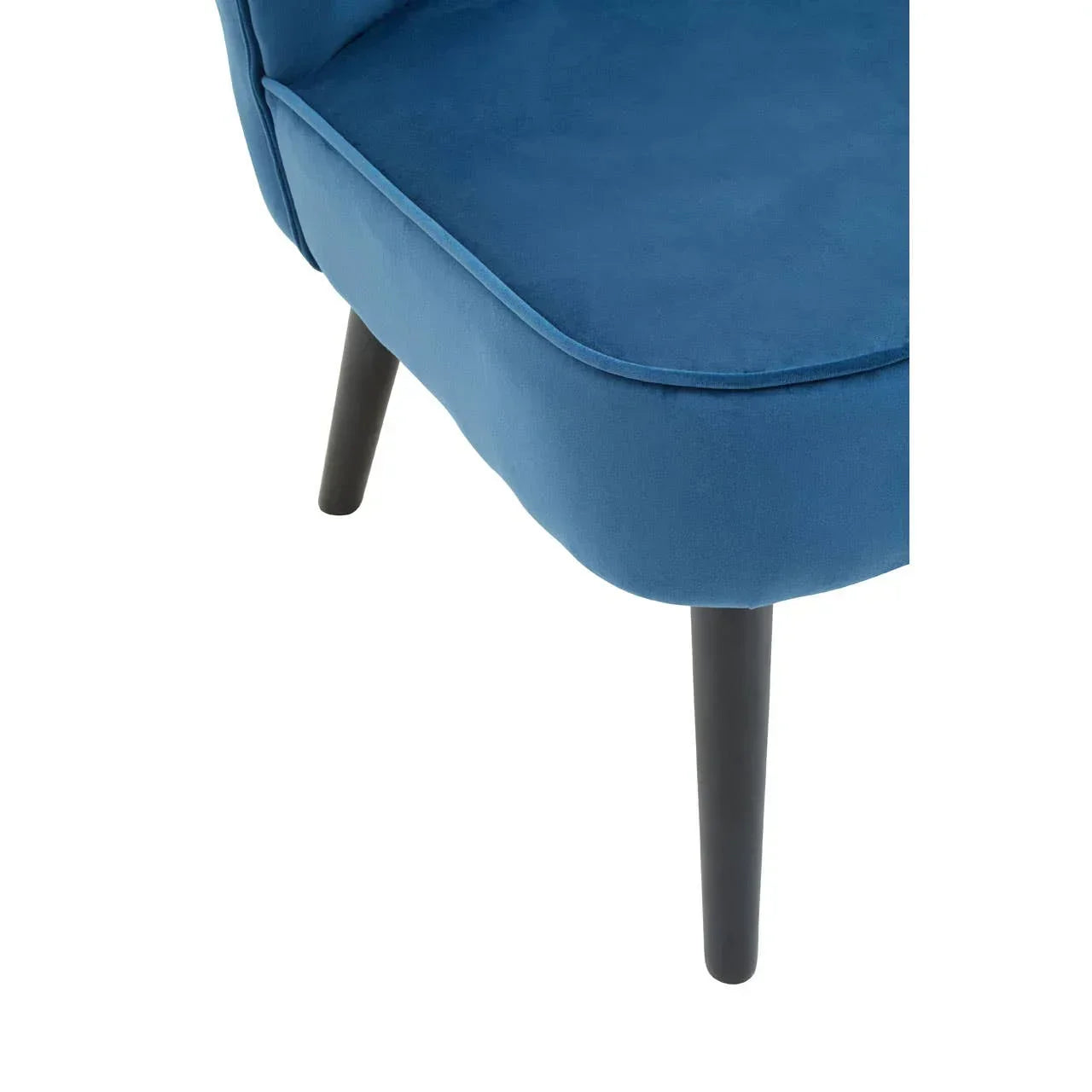 Close-up of blue velvet chair seat with black wooden legs