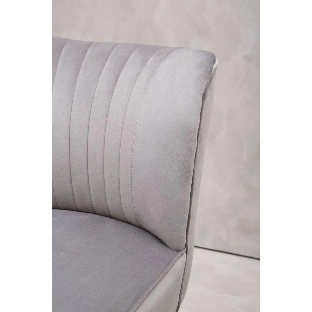 Close-up of grey velvet chair with vertical stitched backrest upholstery