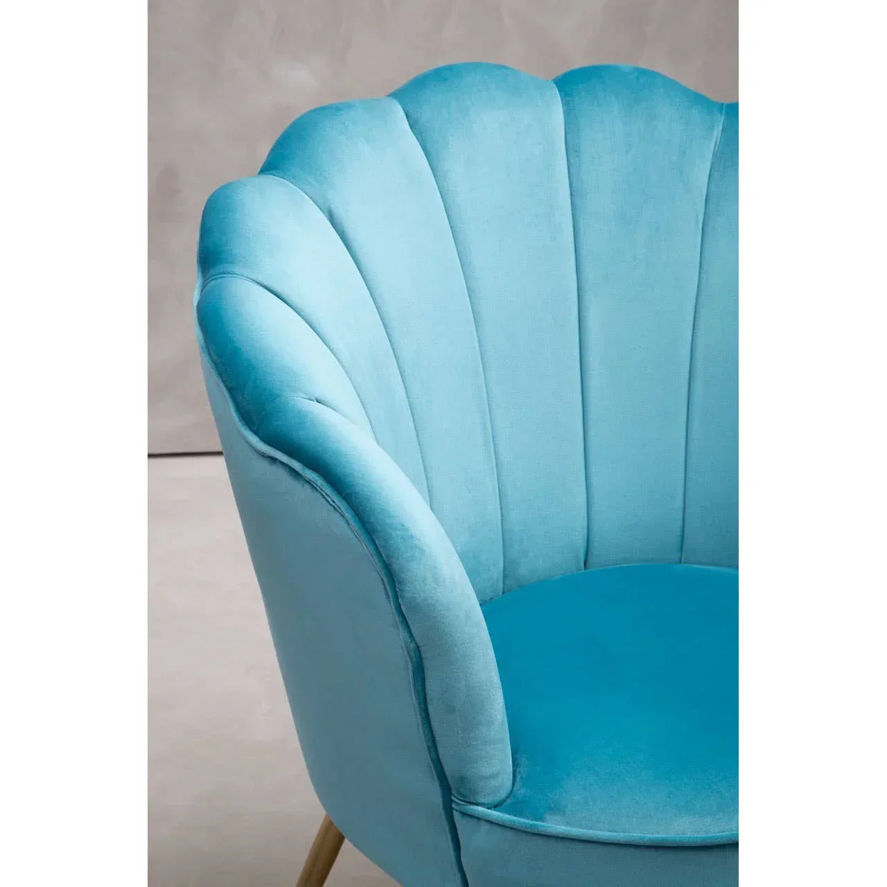 Blue velvet scallop accent chair with curved backrest and plush seat, side view