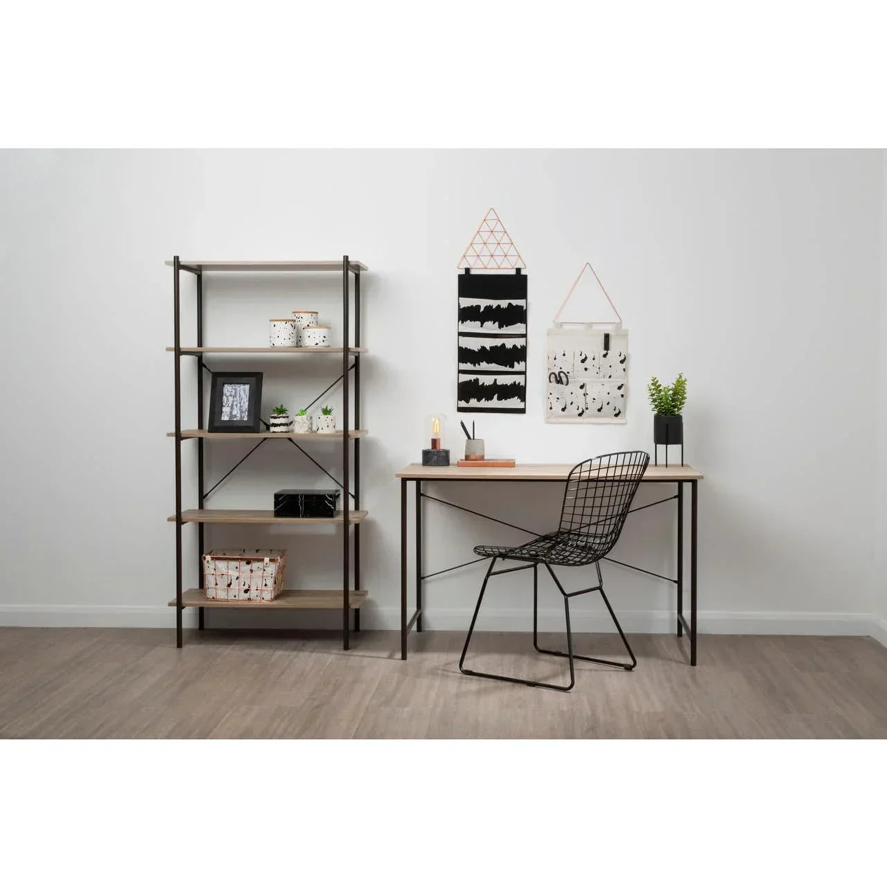 Industrial home office desk with wire chair and shelving unit against white wall