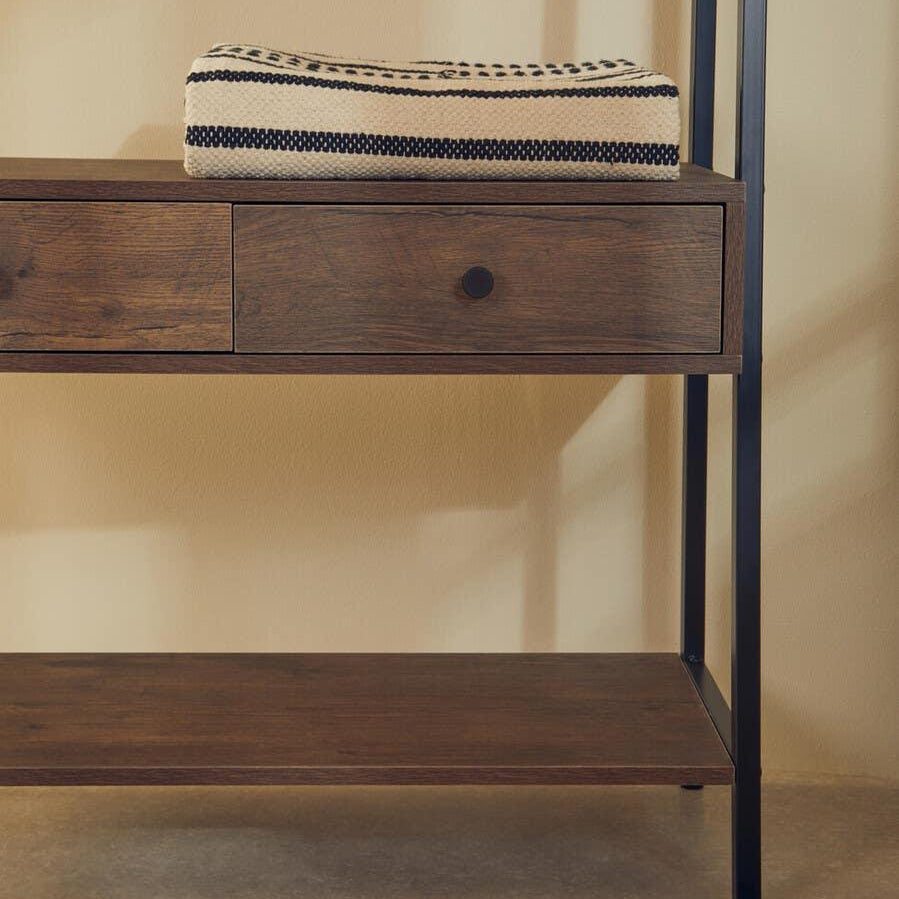 Wood console table with black metal frame, storage drawer and folded striped throw on top