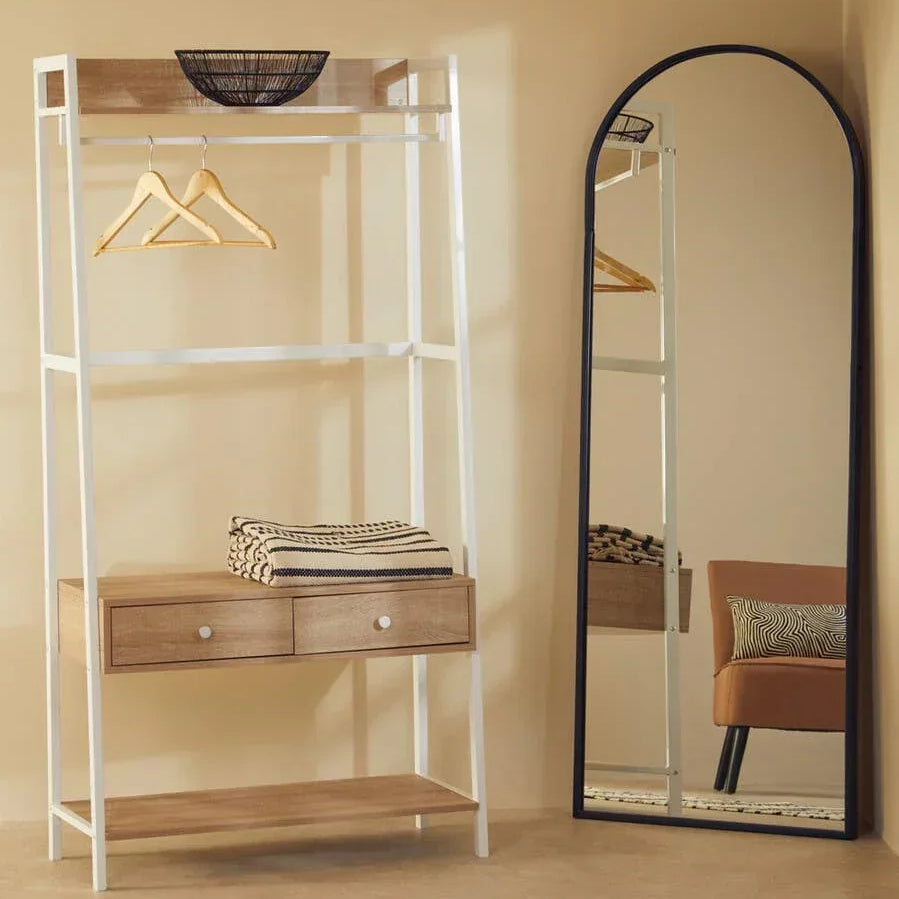 Wood and metal hallway storage rack with drawers beside arched full-length mirror