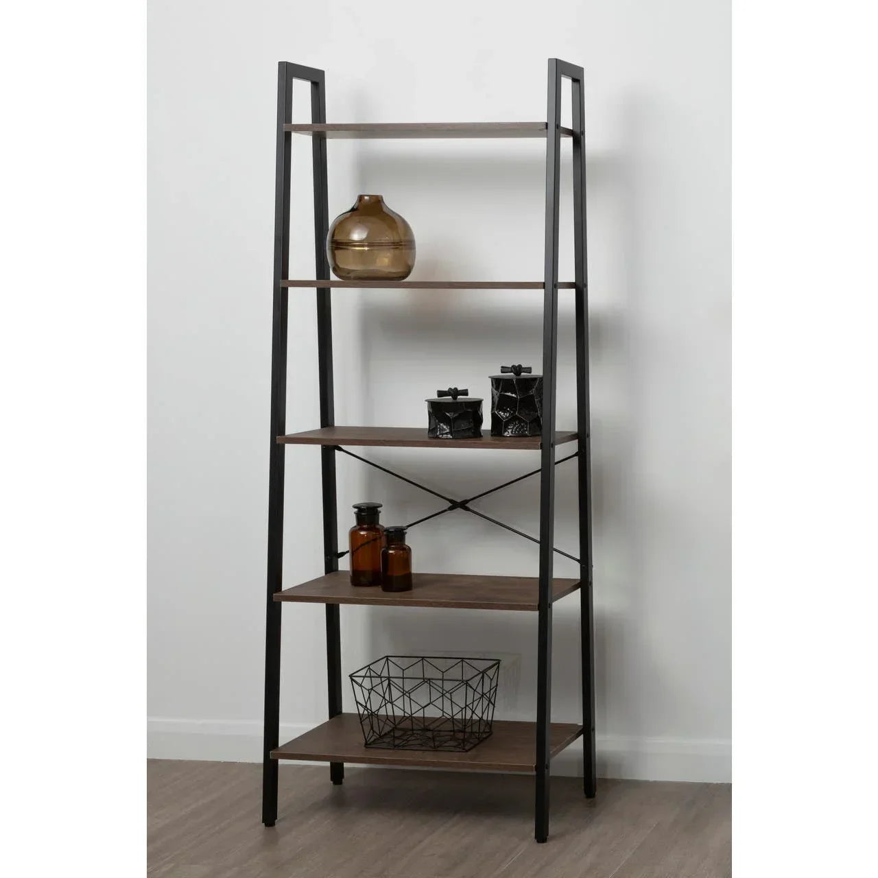 Industrial bookshelf with black metal frame and four wood shelves against white wall