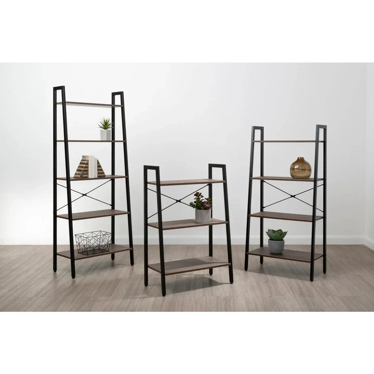 Set of three ladder shelving units with black metal frames and wood shelves in modern room