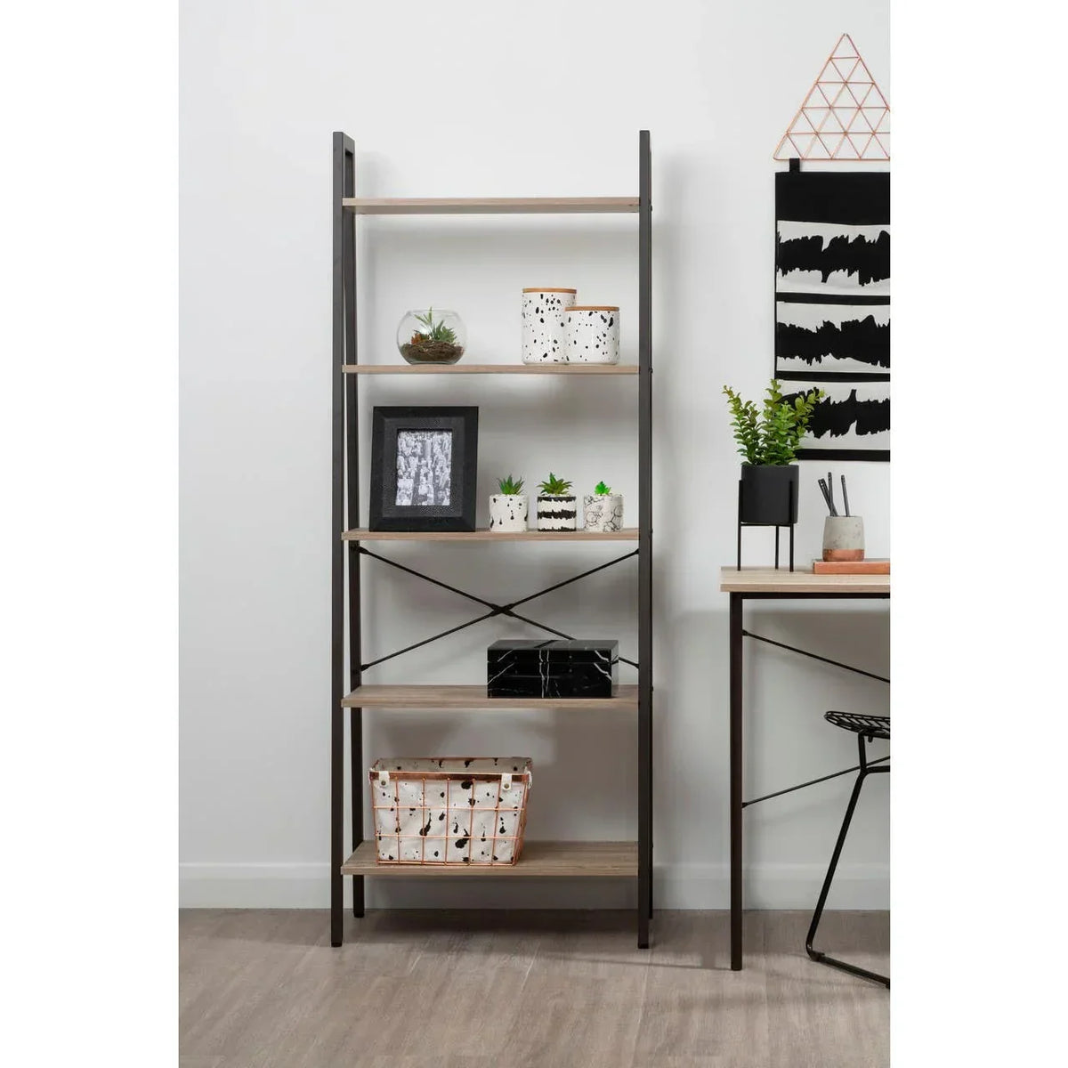 Industrial bookshelf with wooden shelves and black frame styled with plants and decor