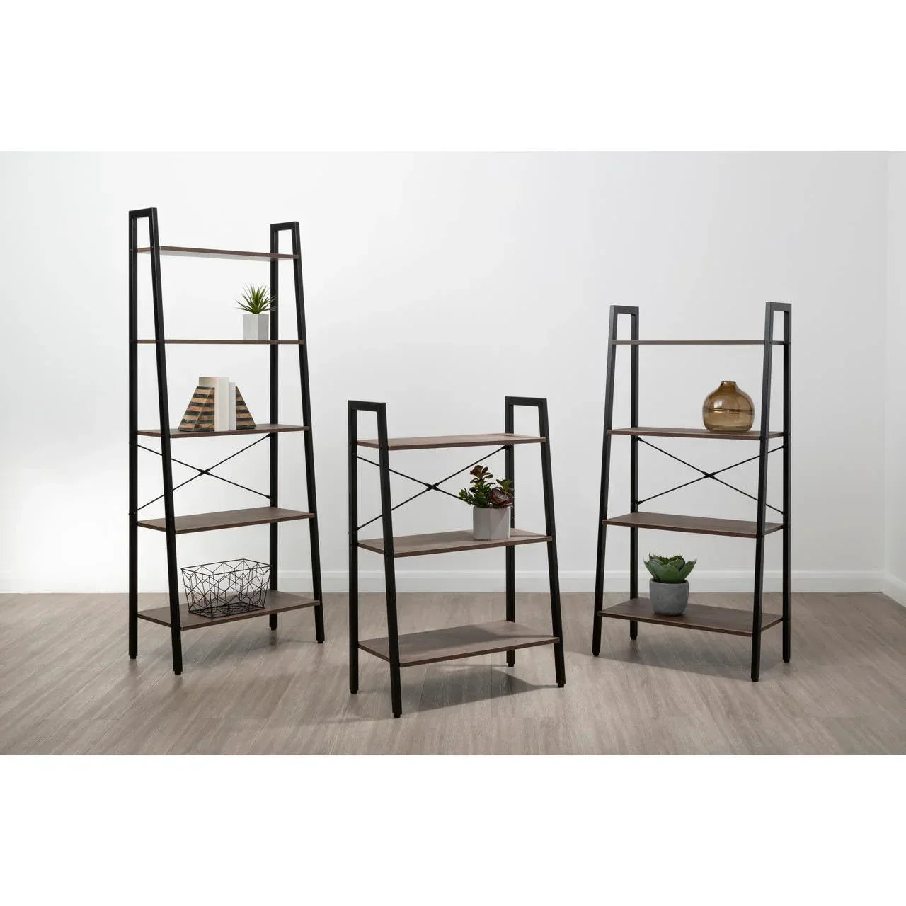 Set of three black metal and wood shelving units with decor in modern room