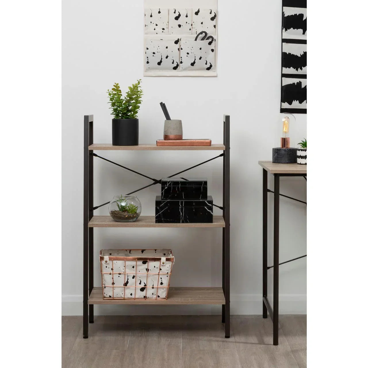 Three tier industrial shelving unit with wood shelves and black metal frame, styled with decor