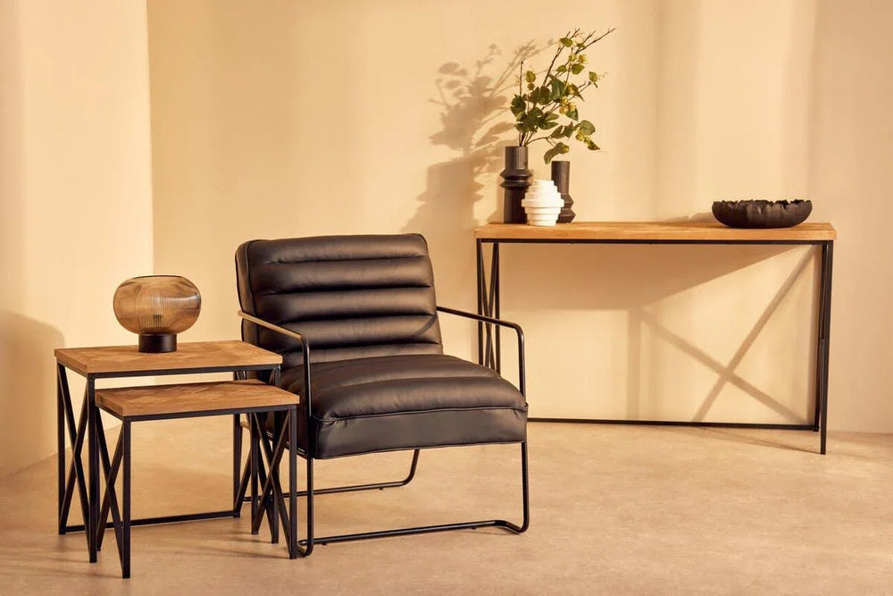 Black leather accent chair with metal frame, nesting tables, and console table in modern living room