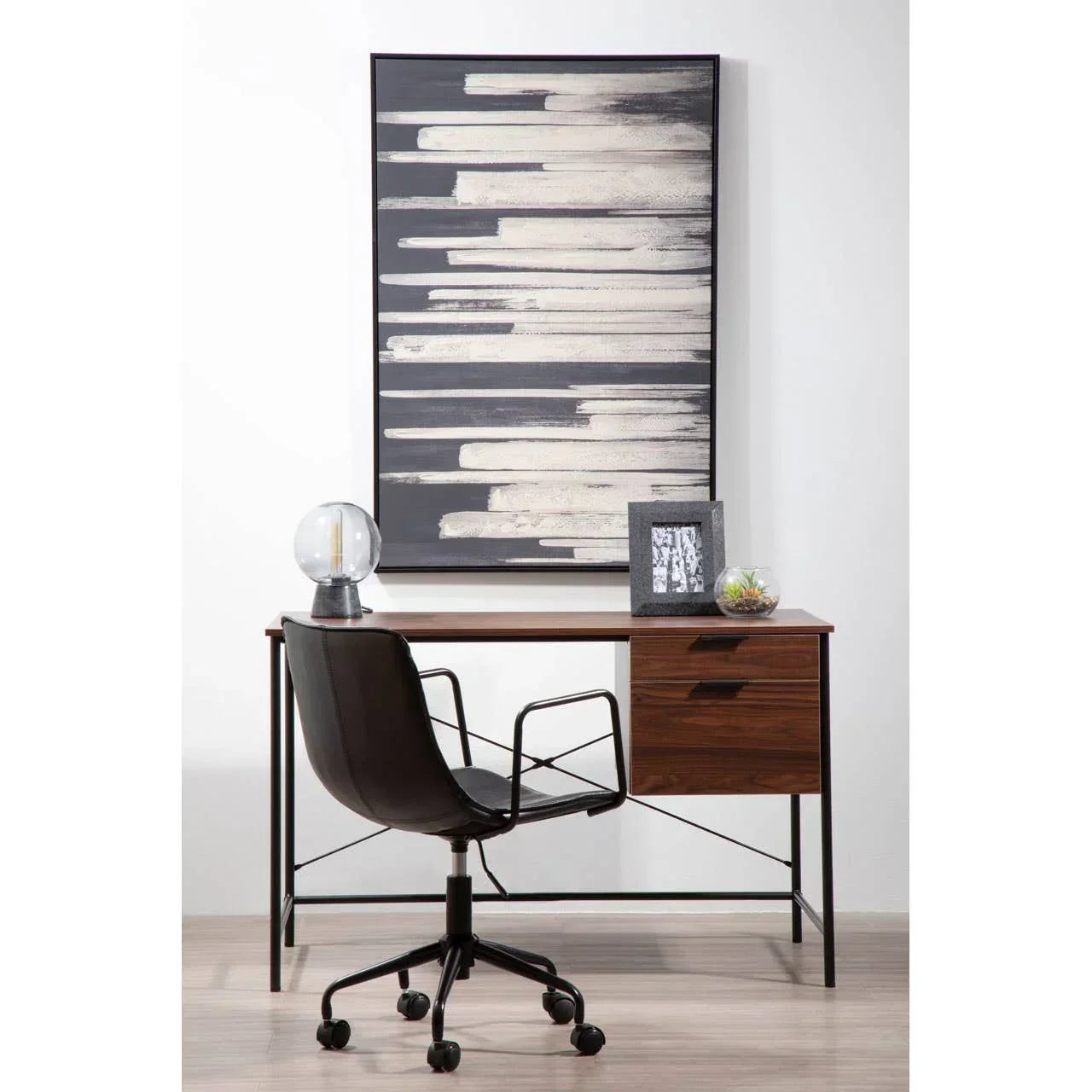 Walnut wood desk with drawers, black office chair and abstract wall art in modern study