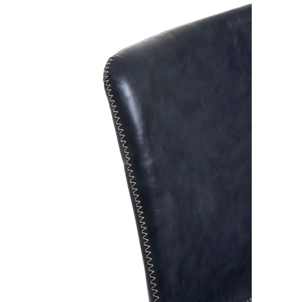 Close-up of black leather dining chair with zigzag stitched edge detail