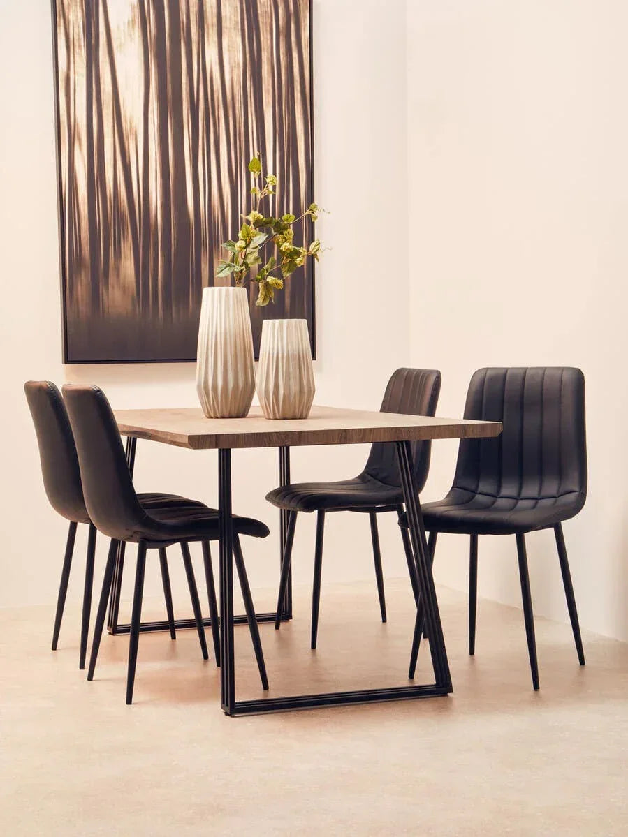 Modern dining table with black chairs and decorative vases in a minimalist dining room