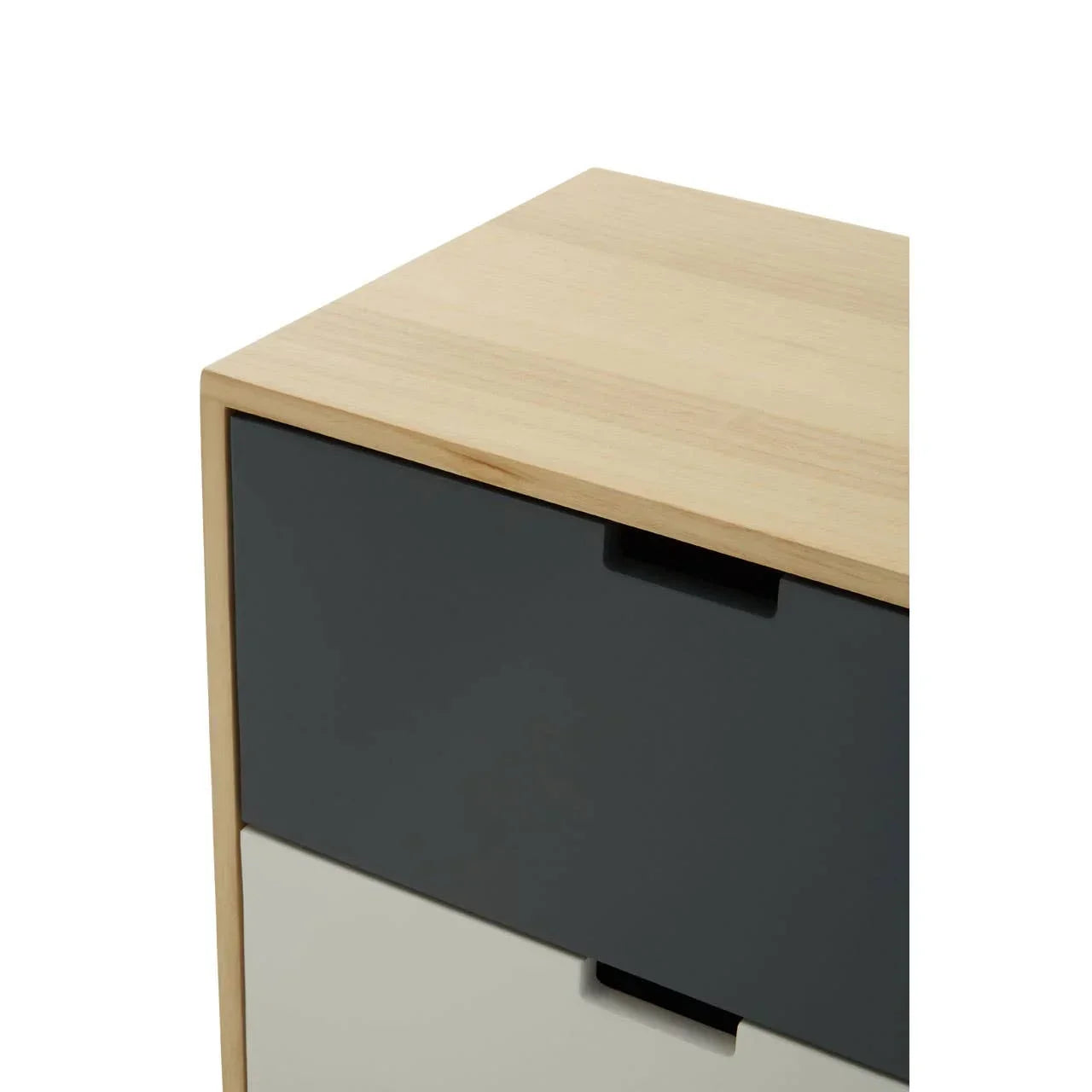 Corner of wooden bedside table with dark grey and cream drawers, close-up view