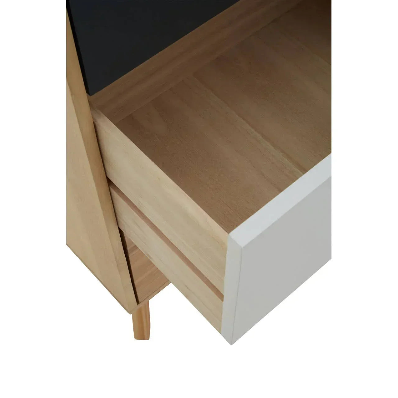 Closeup of wooden bedside table with open white drawer and black tabletop
