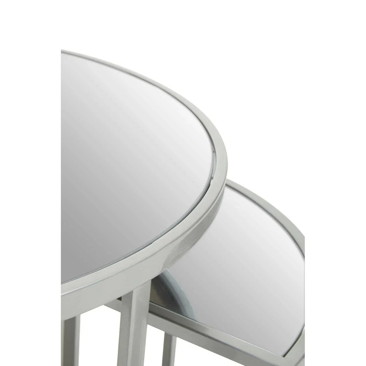 Close-up of two round glass nesting tables with silver metal frames