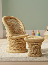 Natural woven bamboo chair and stool set designed for children, featuring a curved chair with a high back and a round stool, both in a light beige color. The chair has a textured surface and a sturdy base, while the stool is slightly shorter and complements the chair's design. In the background, there are colorful toys and a soft rug, creating a playful atmosphere