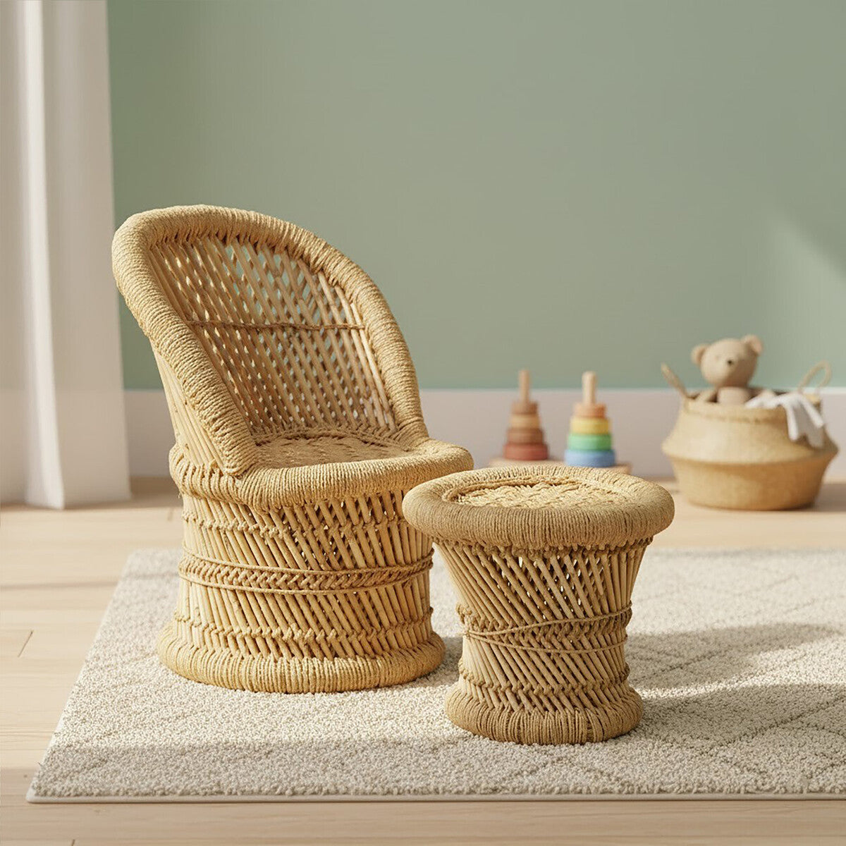 Natural woven bamboo chair and stool set designed for children, featuring a curved chair with a high backrest and a matching round stool, both in a light tan color. The chair and stool are placed on a soft rug in a bright room with a pastel green wall, and colorful toys are visible in the background