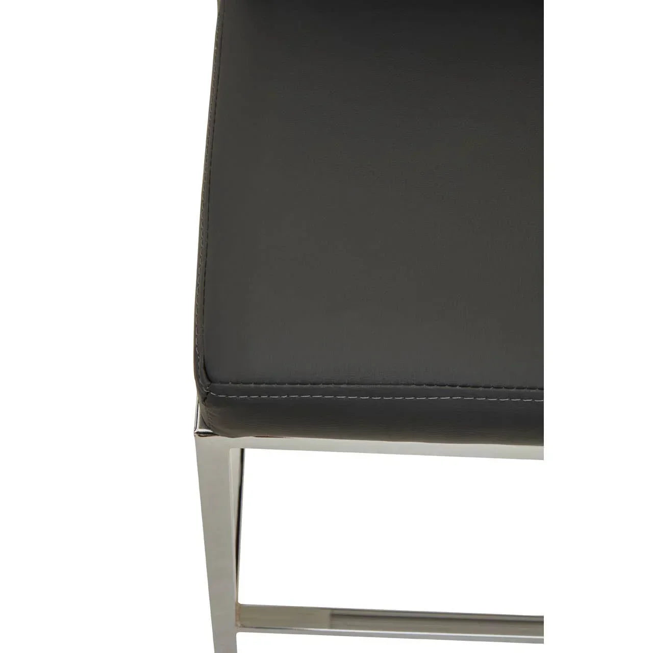 Closeup of black leather dining chair seat with chrome frame and detailed stitching
