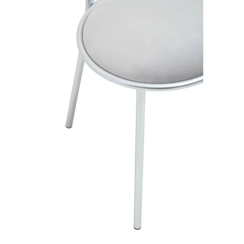 Close-up of silver metal chair leg with round padded seat