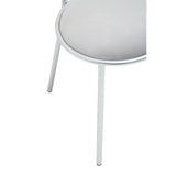 Close-up of silver metal chair leg with round padded seat