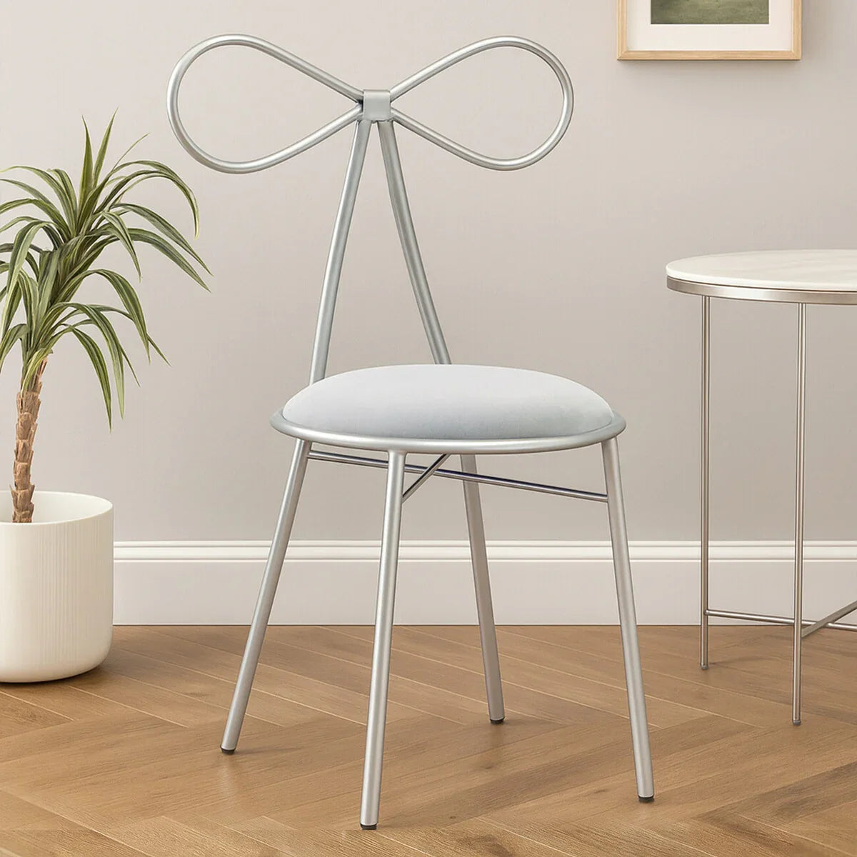 Silver metal accent chair with bow-shaped backrest and cushioned seat in modern room setting