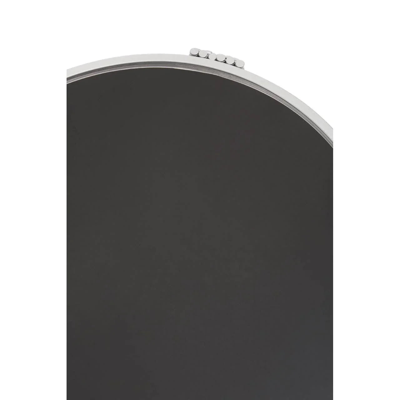 Close-up of round wall mirror with silver metal frame and decorative top detail