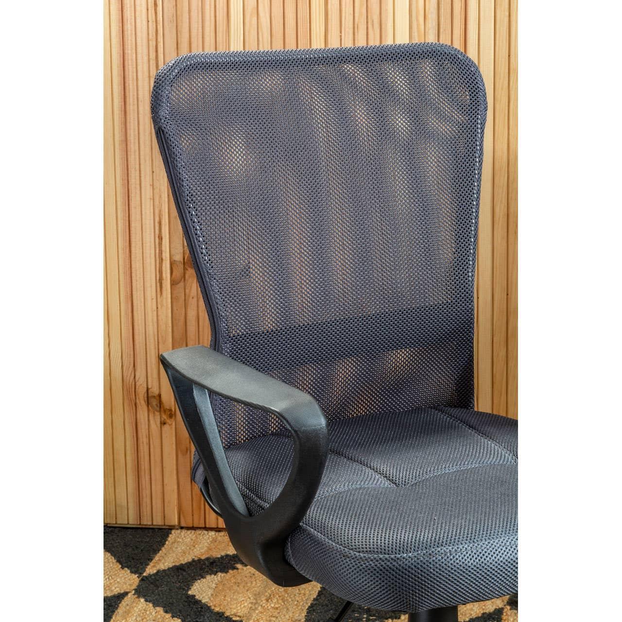 Black mesh office chair with armrest in front of wood panel wall